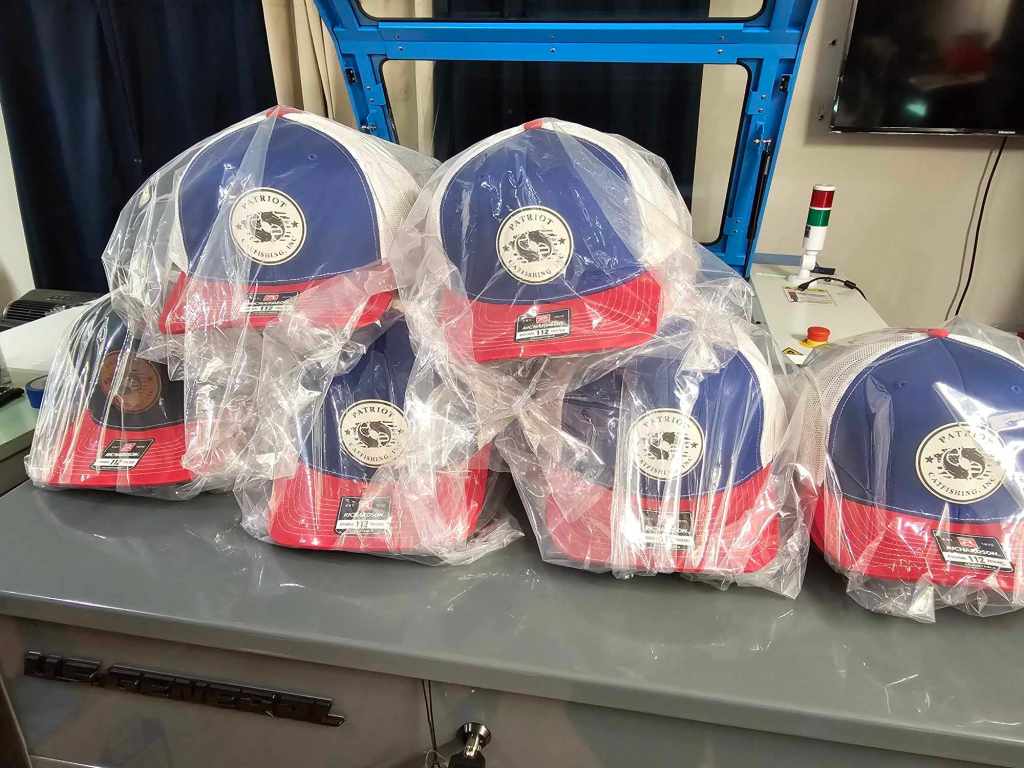 Six wrapped leatherette patch caps displayed on a table.